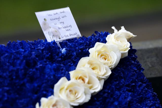 Detail of the card on flowers sent by Rod Stewart to Denis Law's funeral. The flowers form a large Scottish flag and the card reads 'You are, and always will be, my footballing hero. Sir Rod Stewart'