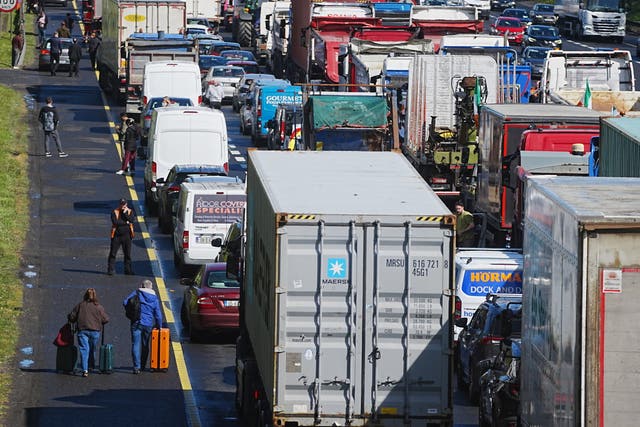 People with their luggage walk past the heavy traffic on Dublin’s M50