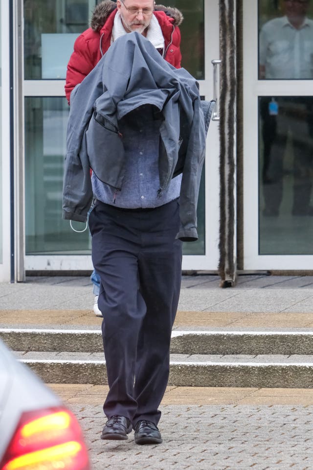 Timothy Schofield covers his head as he leaves Exeter Crown Court during his trial (Matt Keeble/PA)
