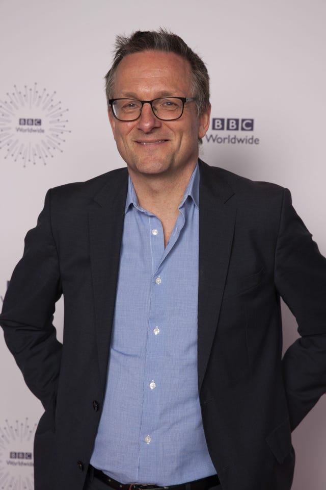 Michael Mosley standing in front of a BBC sign in a black coat and blue shirt