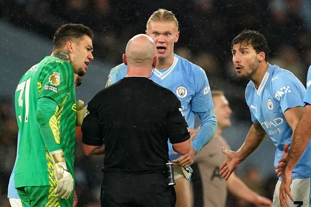 Manchester City player protest to referee Simon Hooper
