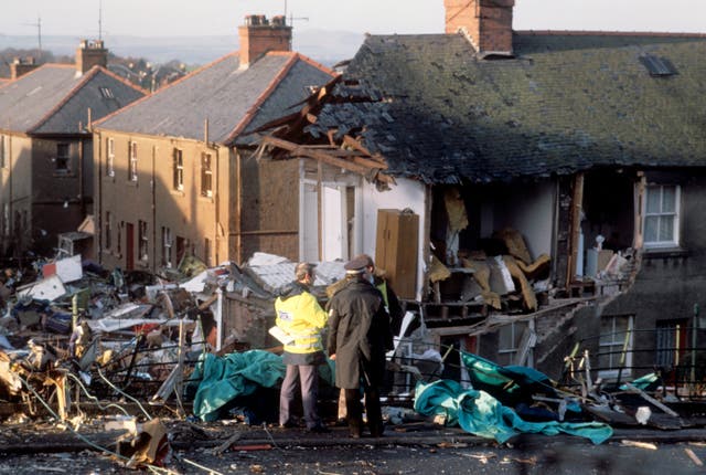 File photo of police officers next to destroyed homes and debris on the ground