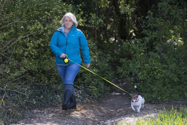 An actress playing the role of PCSO Julia James walks her Jack Russell dog Toby, who was found at the scene, during a reconstruction of the route taken by Julia 