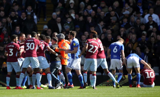 Birmingham supporter Paul Mitchell was led away after attacking Aston Villa’s Jack Grealish on the pitch (right). (Nick Potts/PA)