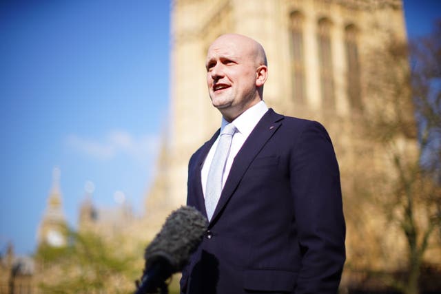 Stephen Flynn stands outside the Houses of Parliament