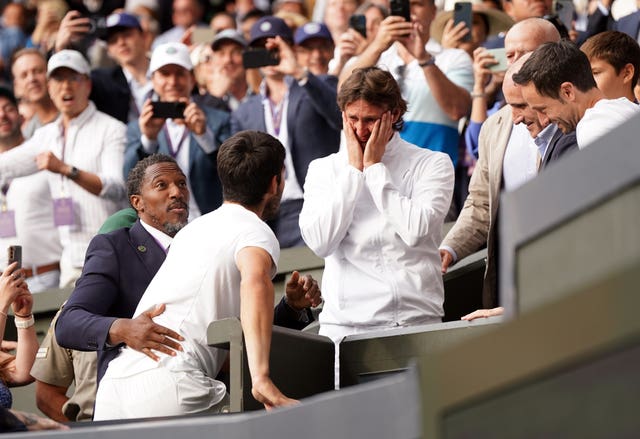 Carlos Alcaraz climbs up to celebrate with coach Juan Carlos Ferrero 