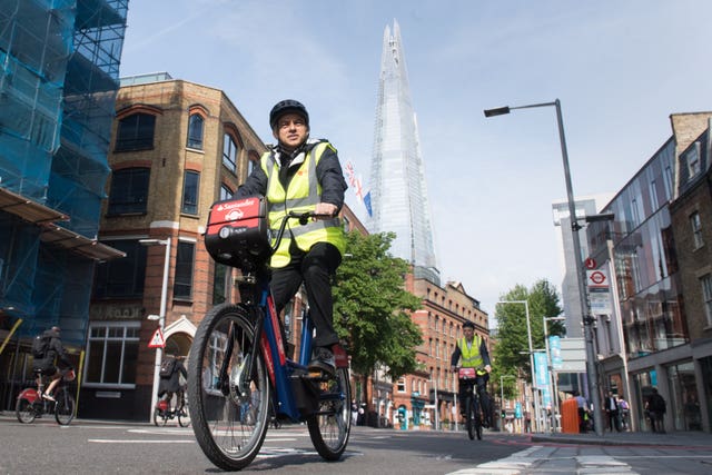 Mayor of London Sadiq Khan rides a legal rental e-bike outside City Hall, London