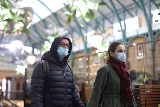 People in Covent Garden wearing face coverings (James Manning/PA)