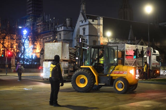 Construction workers put up fencing around the statues in Parliament Square