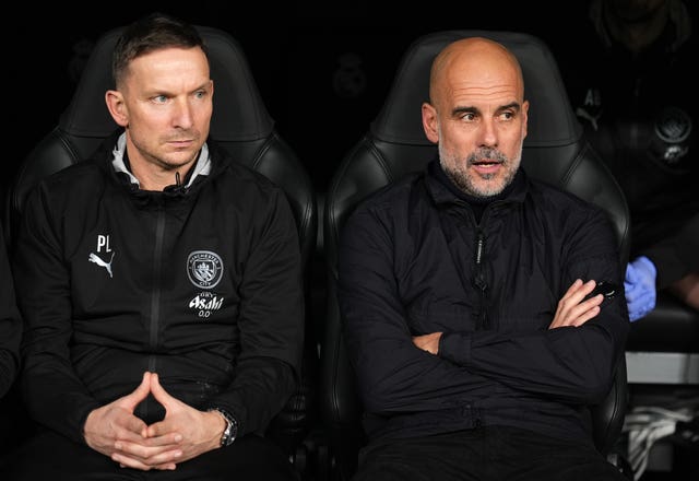 Pep Guardiola (right) sitting with assistant Pep Lijnders 