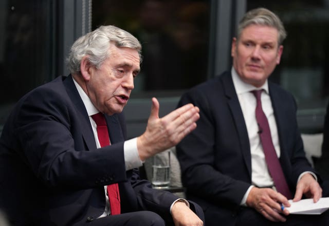 Gordon Brown gesturing as Sir Keir Starmer watches