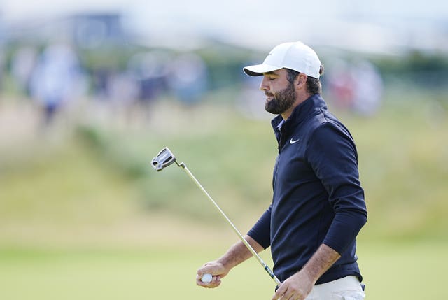 Scottie Scheffler carries his putter