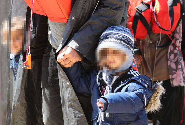 A group of people, including children, are brought in to Dover