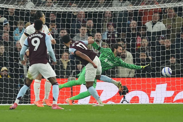 Alisson Becker cannot stop Ollie Watkins' header diving to his left