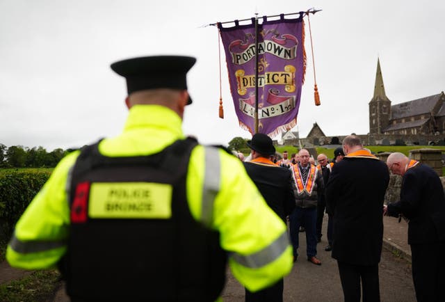 Orangemen make their way from Drumcree Church as police form a barricade to prevent them entering the Garvaghy Road during the stand-off