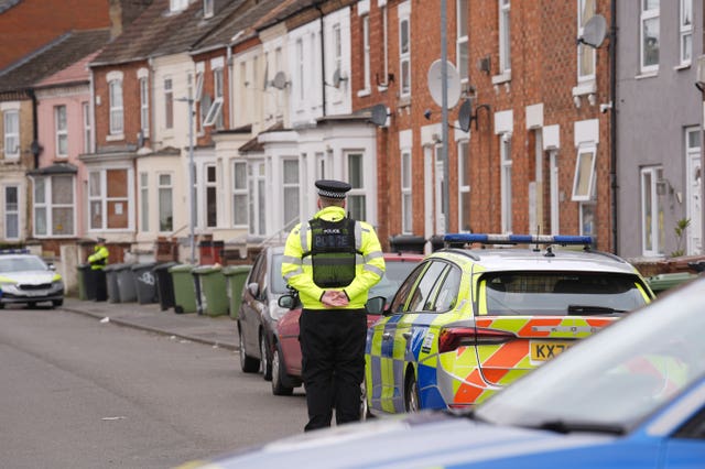 Police officer, seen from behind, and police car in a street 