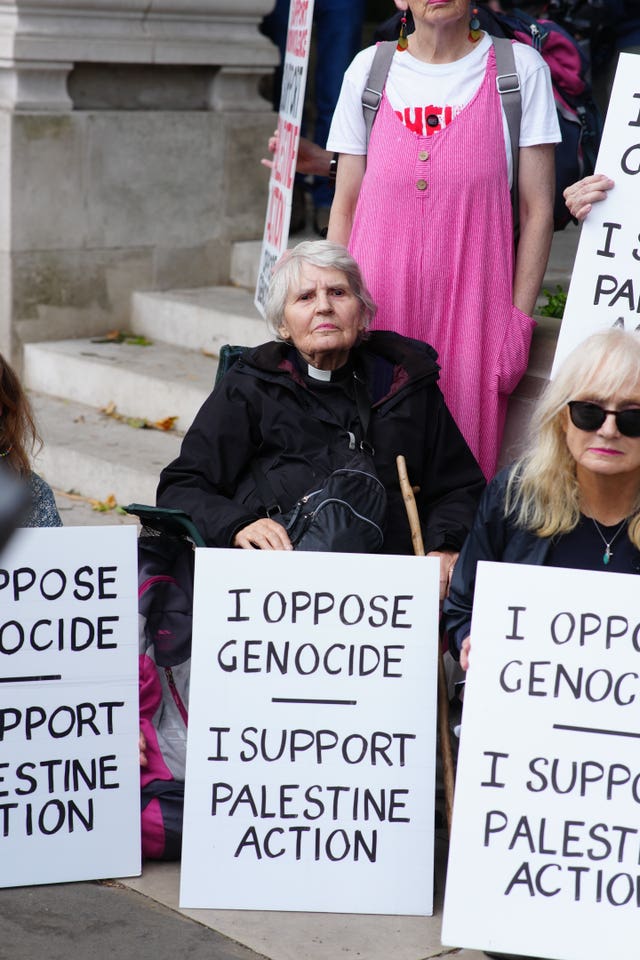 Protesters, including a female vicar, holding signs which read 'I oppose genocide, I support Palestine Action'