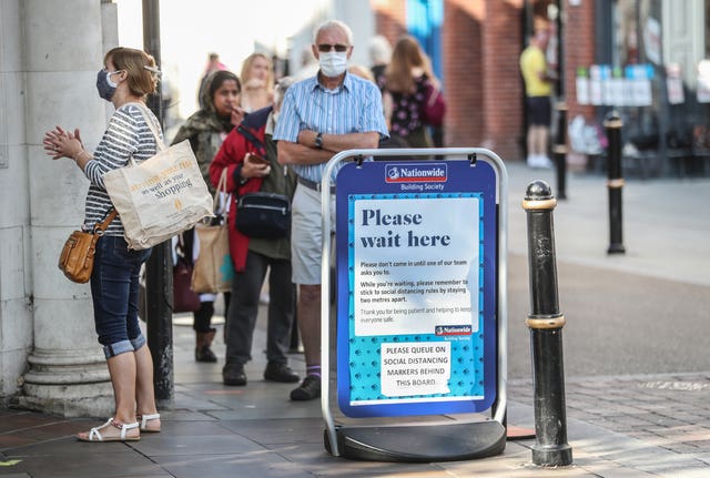 Customers in a socially distanced queue wait by a sign to enter the Nationwide Building Society in the High Street in Worcester, some six months on from the evening of March 23 when Prime Minister Boris Johnson announced nationwide restrictions 