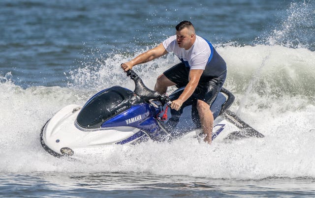 A man on a jet ski enjoys the warm weather on Scarborough beach, North Yorkshire 