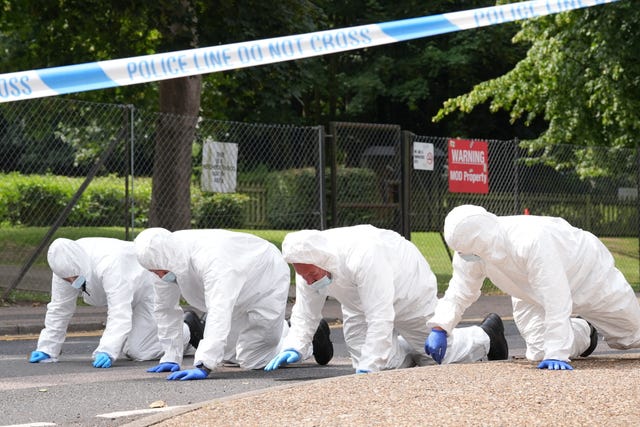 Forensic officers search near the scene in Sally Port  Gardens 