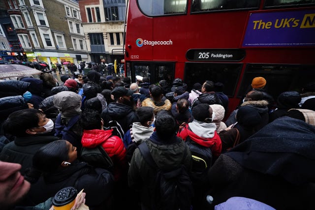 People crowd to get on a bus at Liverpool Street station in central London