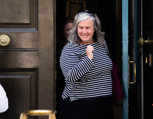 Heidi Alexander smiling as she exits a building