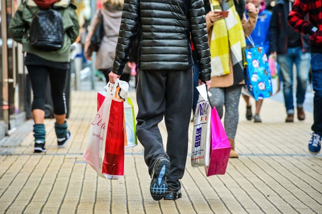 A person carrying shopping bags walking down a street