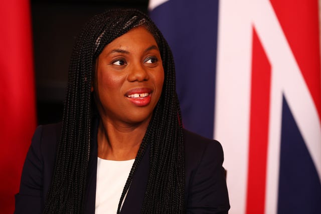 Kemi Badenoch smiles with a Union flag graphic as a background