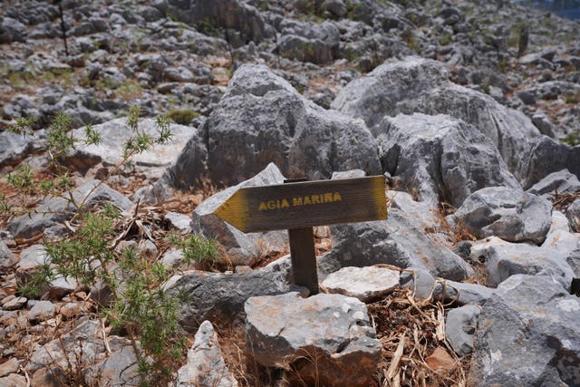 A direction sign on a rocky path in the hills of Pedi, a small fishing village in Symi, Greece