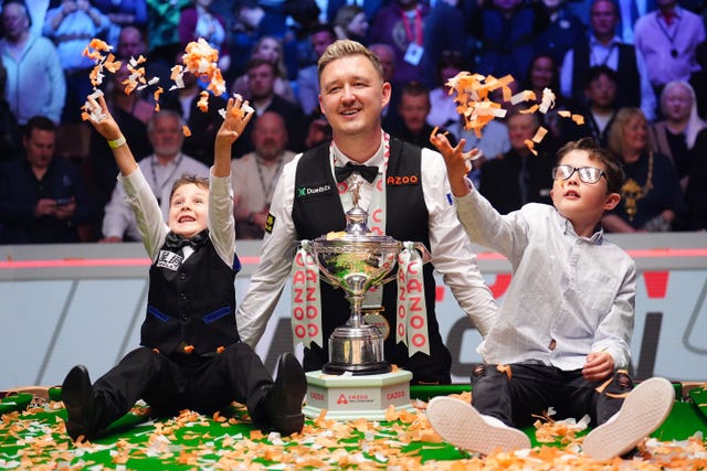 Kyren Wilson celebrates his World Championship win as his children sit on the table throwing confetti