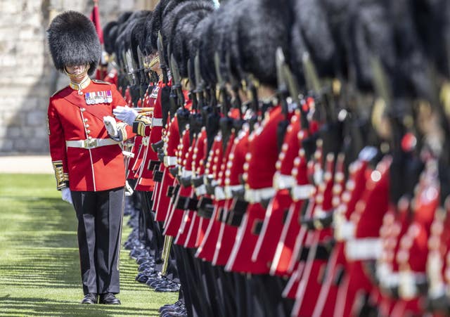A warrant officer of the 1st battalion Irish Guards makes sure the line of guardsmen is straight as the regiment lines up on parade in the Quadrangle of Windsor Castle where their new regimental colours were presented to them by the Duke of Cambridge