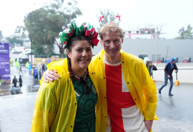 A Mexico fan and an England fan in raincoats ahead of the game 