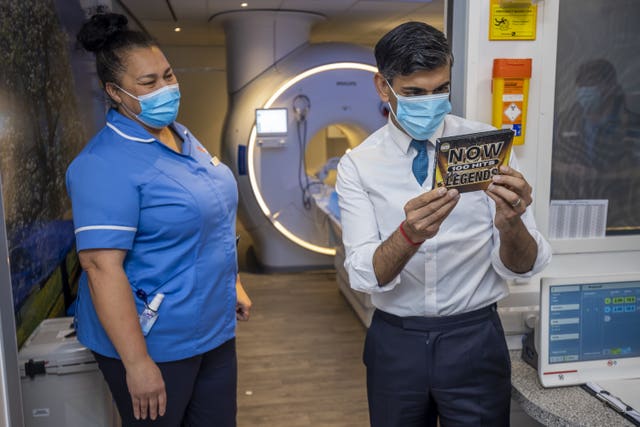 Prime Minister Rishi Sunak looks at a CD that is offered to patients while they have MRI scans during a visit to Oldham Community Diagnostic Centre in Greater Manchester