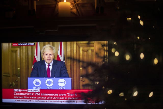 TV showing Boris Johnson placed near Christmas tree