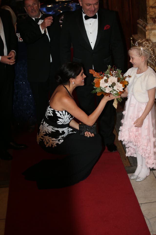 The Duchess of Sussex is presented with a bouquet 