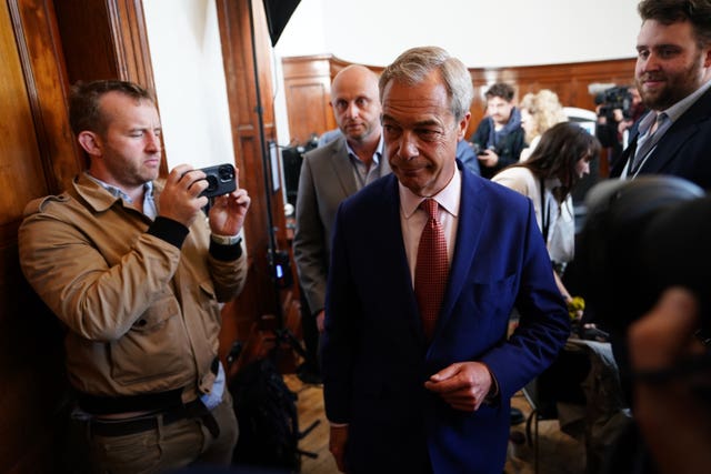 Nigel Farage walks past photographers as he leaves the Wellington Hotel after holding a press conference