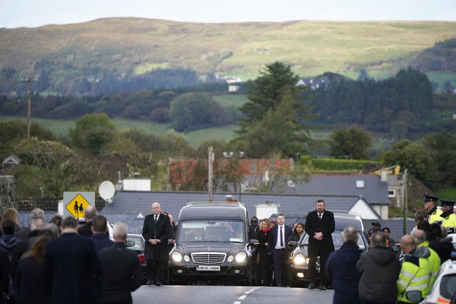 Family and mourners arrive at St Michael’s Church, in Creeslough, alongside the hearse