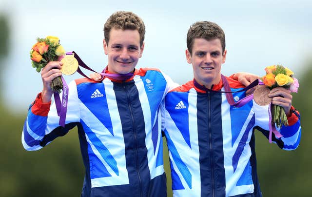 Great Britain’s Alistair Brownlee celebrates with his gold medal and Jonathan Brownlee (right) celebrates with his bronze medal,