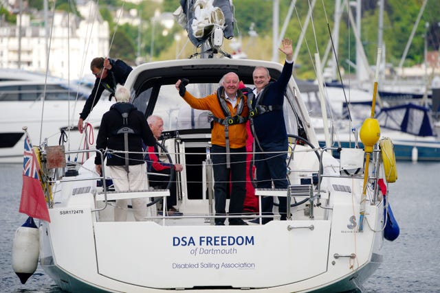 Lib Dem candidate Steve Darling and party leader Ed Davey on board the Disabled Sailing Association boat DS Freedom and waving from the stern 