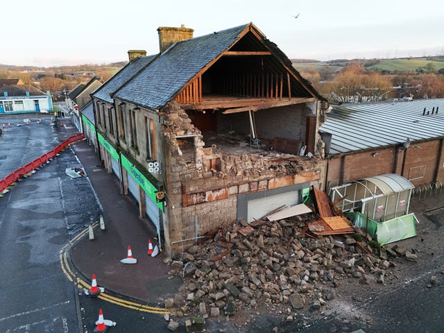 Co-op shop with the side of the building collapsed, with bricks lying across the ground