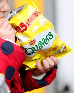 a child eating a packet of Quavers crisps