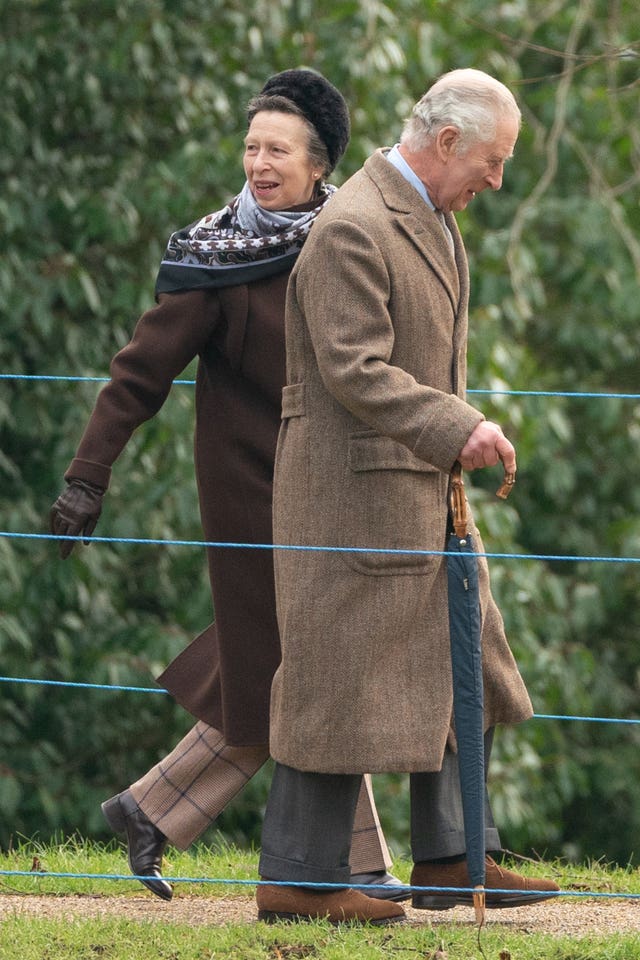 The King and the Princess Royal wearing brown coats walking to church
