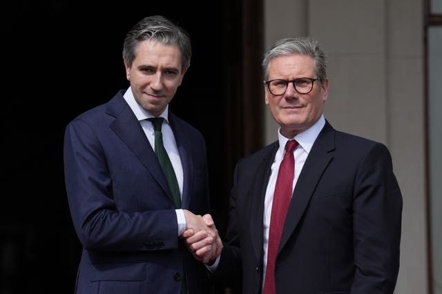 Simon Harris, left, shaking hands with Sir Keir Starmer as the pair pose for photographs