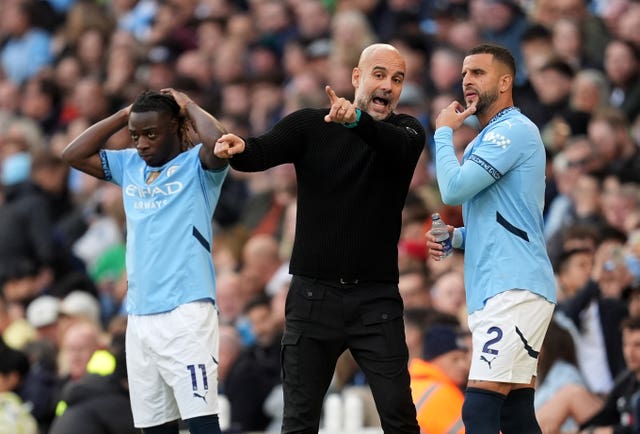 Manchester City manager Pep Guardiola speaks with substitute Kyle Walker (right) on the touchline