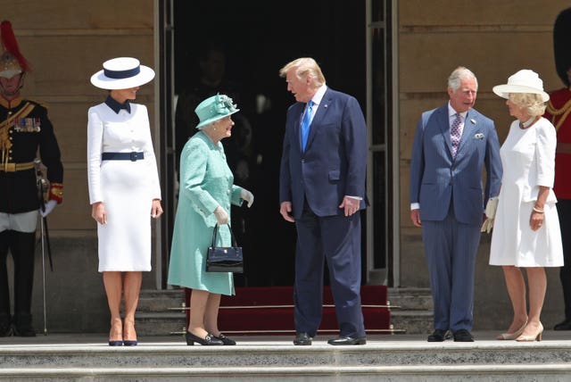 Donald Trump and his wife Melania are welcomed by the late Queen Elizabeth II