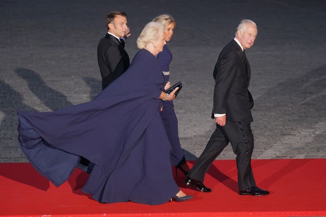 KCamilla dazzled in a midnight blue silk crepe dress and matching cape by Dior