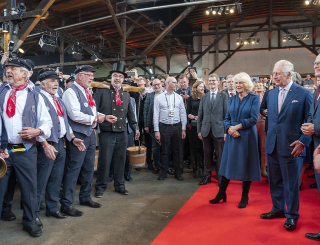 The King and the Queen Consort listen to a sea shanty group during a reception at Schuppen 52, Hamburg