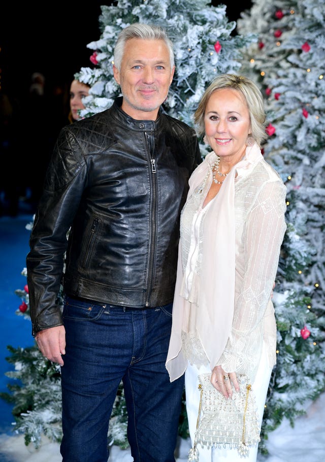 Martin Kemp and his wife, Shirlie, posing in front of a Christmas tree.