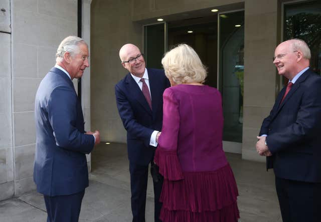 The Prince of Wales and Duchess of Cornwall are greeted by Clive Marshall, chief executive of the PA Group and chairman Murdoch MacLennan (Yui Mok/PA)