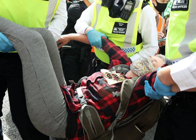 An Extinction Rebellion protester is removed by police officers near Parliament Square 